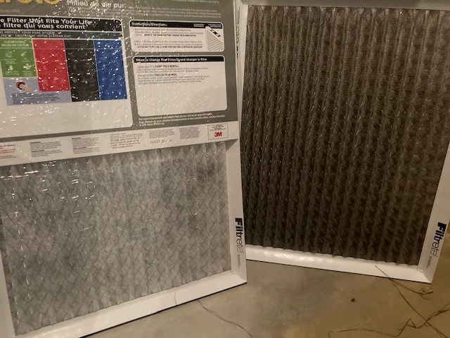 One dirty furnace filter beside one clean furnace filter